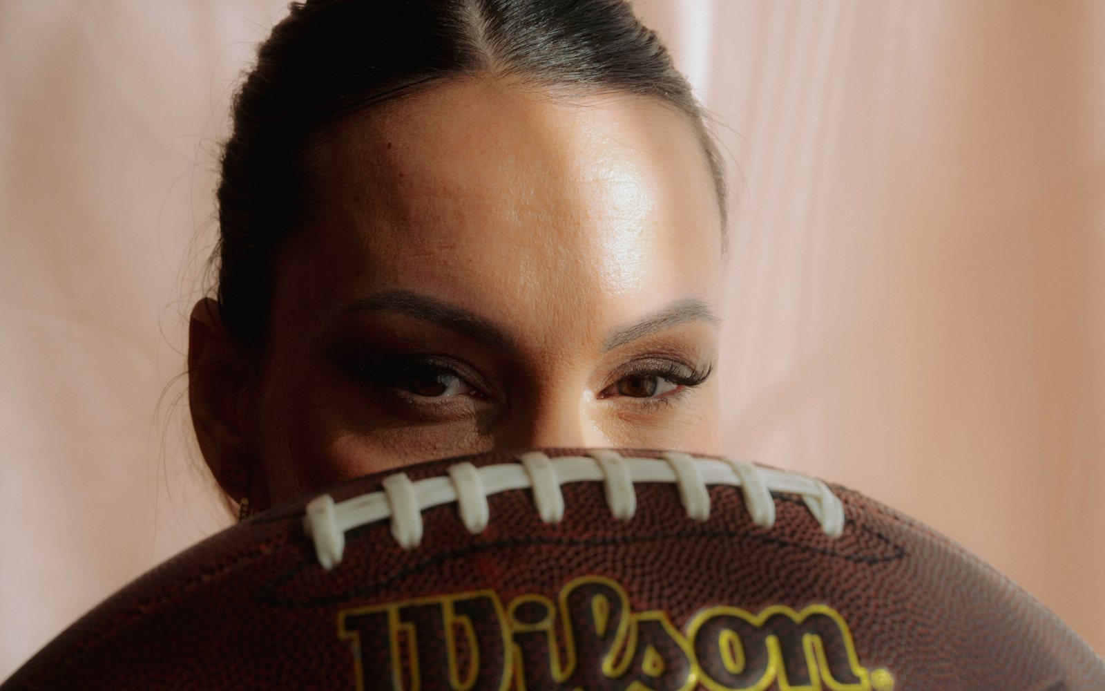 Stephy schaut über einen Football hinweg in die Kamera
